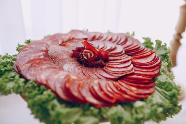 Close-up of thinly sliced Jamón Ibérico with a rich, marbled texture and a reddish-brown color.