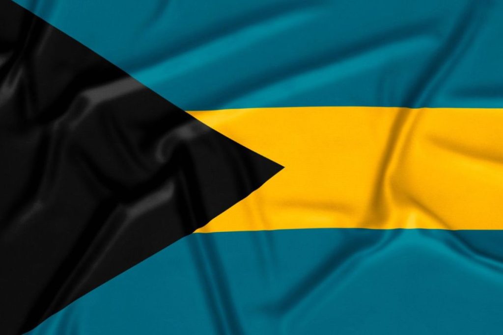 Flag of the Bahamas flag with black triangle, aquamarine stripes, and gold stripe.